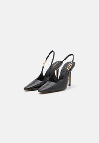 Črne patentne usnjene pete z oblogo in ostro konico, teksturiran vzorec krokodila ter ozek stiletto peto. Zlata strojna oprema kot okras na peti.