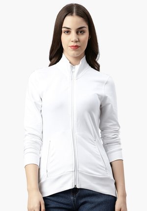 Giacca bianca con zip, colletto alto, maniche lunghe e tasche laterali. Tessuto liscio con polsini e orlo a coste. Design casual e aderente.