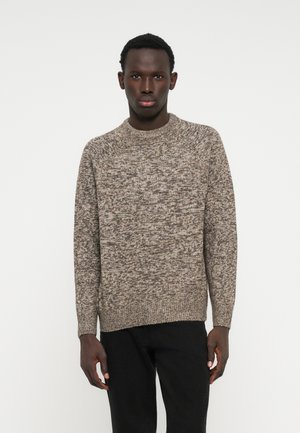 Knit sweater in a textured, speckled pattern of beige and brown hues. Features a crew neck and long sleeves, with a relaxed fit.