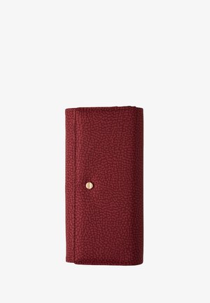 Gefaltete dunkelrote, strukturierte Geldbörse mit einem kleinen runden goldenen Druckknopfverschluss auf der Vorderseite, isoliert vor Hintergrund in Weiß.