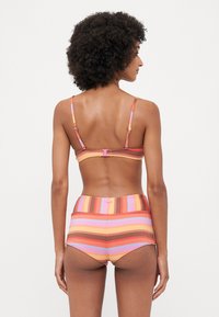 Csíkos bikini szett, amely élénk színekkel, narancs, rózsaszín és lila árnyalatokban készült, texturált anyagból, állítható pántokkal.