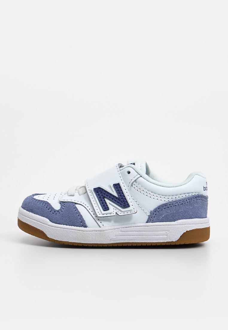 Sneaker bianco con accenti blu chiaro e viola, materiali in suede e pelle, cinturino in Velcro, suola in gomma con grip testurizzato e punta arrotondata.