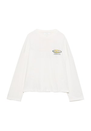 T-shirt en coton blanc à manches longues avec une coupe ample, ornée d'un graphique sur la poitrine incluant le texte "vivre pleinement" et un design coloré.