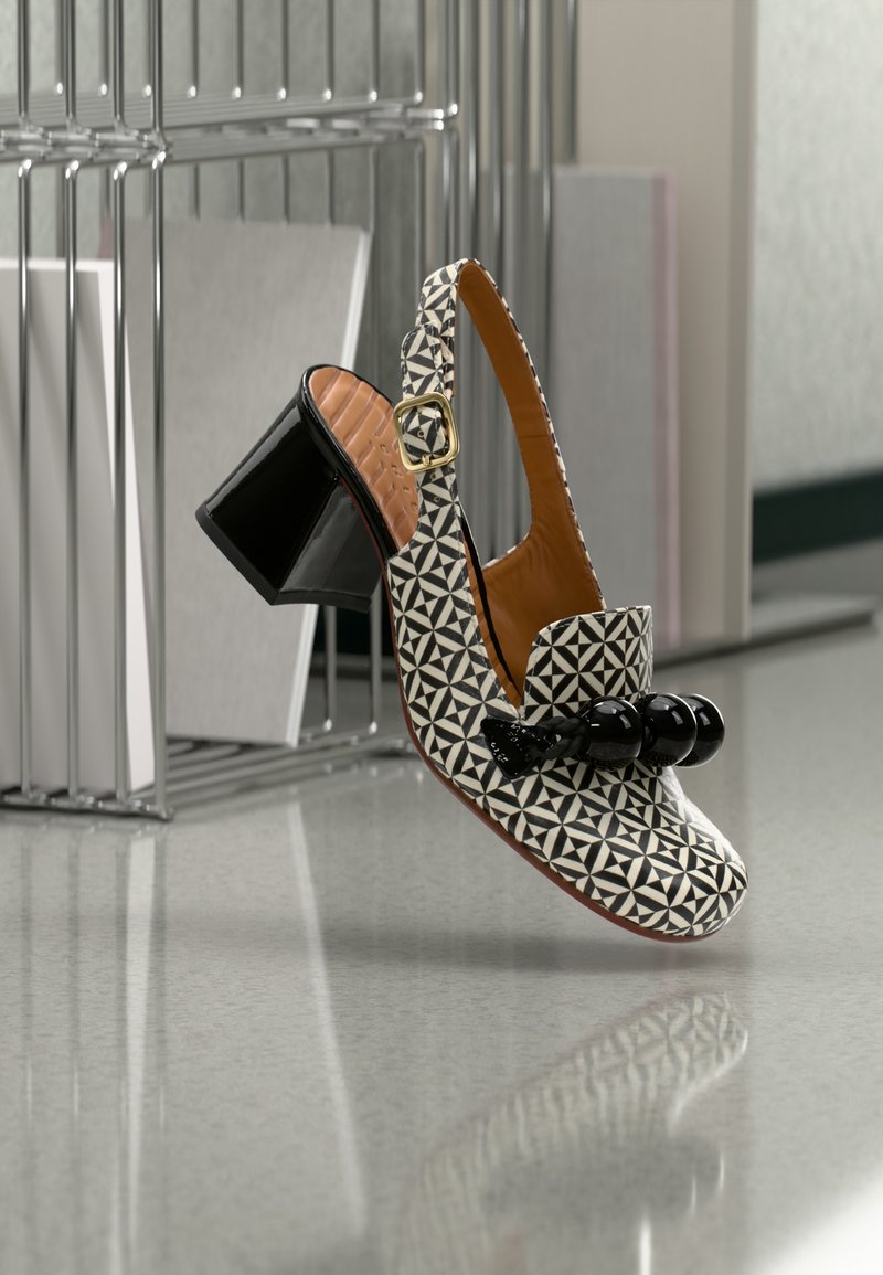 Chaussure à talons avec bride arrière en motif géométrique noir et blanc, finition lisse semblable au cuir et décoration en perles rondes à l'avant.