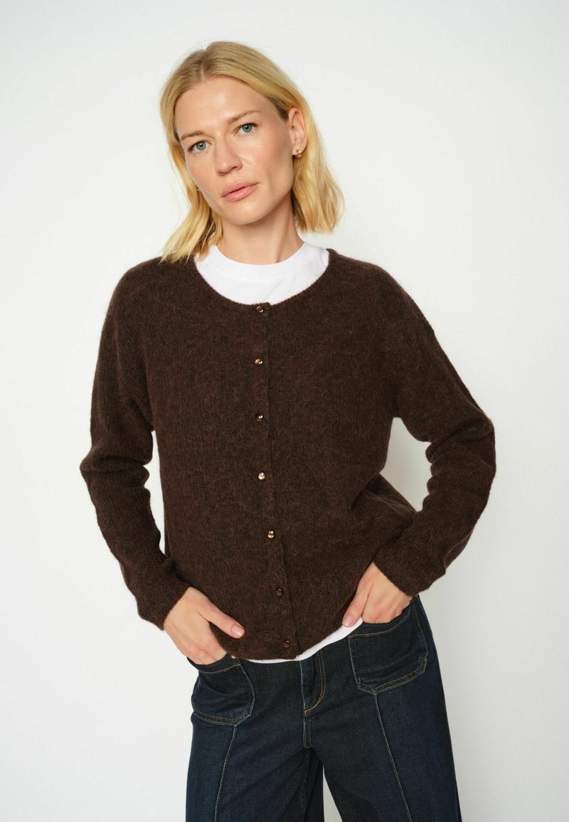 Cardigan marrón, suave, hecho de material borroso, con cuello redondo, mangas largas y botones decorativos en el frente.