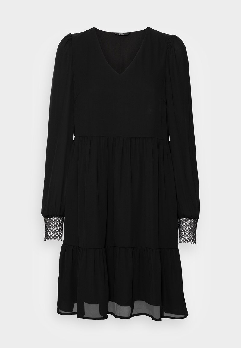 Black dress with long sleeves, V-neck, tiered skirt, and lace detail at the sleeve cuffs. Made from a flowing fabric, semi-sheer hem.