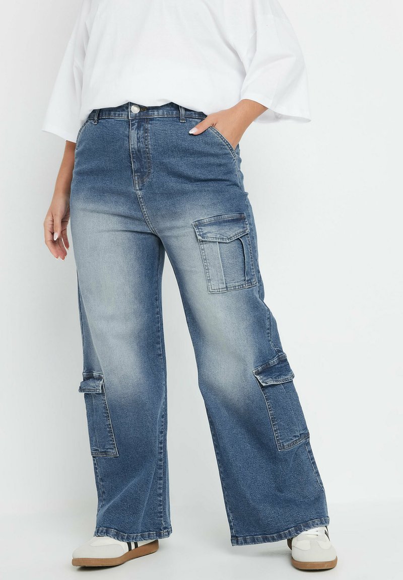 Sininen farkkukankainen cargo-housut, joissa on rento istuvuus, suuret sivutaskut, korkea vyötärö ja haalistunut pesu vintage-tyylin saavuttamiseksi.