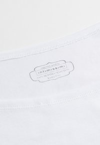 Wit katoenen stof met een gladde textuur. Label leest "intimissimi" en vermeldt 100% Supima katoen, extra fijne kwaliteit. Eenvoudige stikstofdetails.