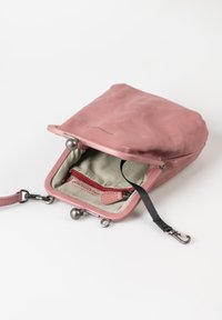 Rosa Ledertasche mit einem Metallverschluss, ausgestattet mit einem gestreiften Innenraum, einer roten Reißverschlusstasche und einem schwarzen Riemenanschluss.