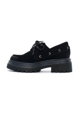 Scarpa nera in suede con lacci, punta rotonda, suola a piattaforma spessa e occhielli dorati. Presenta un design testurizzato, profilo basso e accenti laterali.