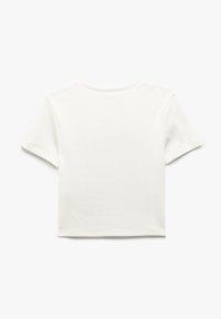 Camiseta blanca de manga corta con escote redondo, hecha de tela de algodón acanalada, con un diseño corto y un acabado limpio en el dobladillo.