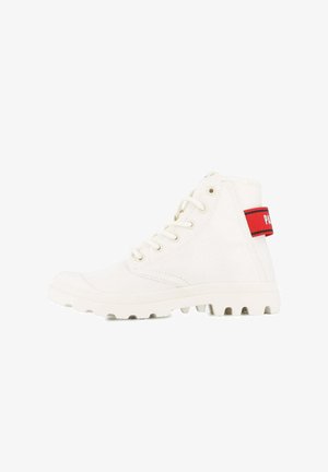 Scarpe alte bianche in tela con finitura testurizzata, caratterizzate da un accento rosso sul tallone e una suola robusta per una maggiore aderenza.