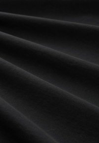 Schwarzer Stoff mit einer glatten Textur, der subtile Falten und eine weiche, matte Oberfläche aufweist. Einheitliche Farbe ohne sichtbare Muster oder Details.