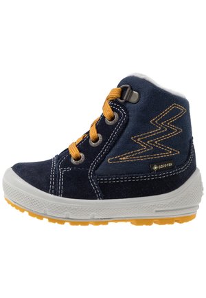 Botte enfant montante en daim bleu marine avec lacets jaunes, semelle blanche, bande de roulement jaune, étiquette Gore-Tex et couture en zigzag sur le côté.