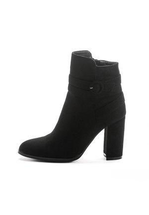 Bottines noires à talons hauts en daim, dotées d'un revers replié, d'une sangle décorative avec boucle circulaire et d'un talon bloc texturé.