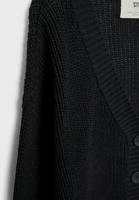 Zwarte gebreide cardigan met een textuurontwerp, diepe V-hals en grote knopen. De stof lijkt zacht en ademend.