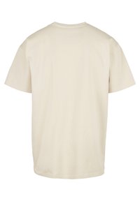 Tricou bej cu mânecă scurtă din bumbac. Are guler rotund și un tiv drept. Design simplu, fără modele sau accente vizibile.