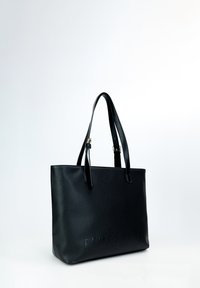 Zwarte leren tote bag met een textuurafwerking, voorzien van twee handvatten en reliëfletters aan de voorkant. Minimalistisch ontwerp.