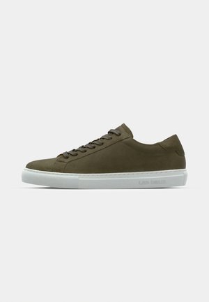 Olive rohelise nubukist sneaker valge kummist tallaga, ümmarguse toe ja lamedate paeltega. Küljel on brändi nimi "LES DEUX." Sile tekstuur.
