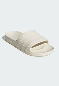 White rubber slide sandal with three horizontal ridges across the top, a textured footbed, and a smooth sole. Features logo detail on the side.