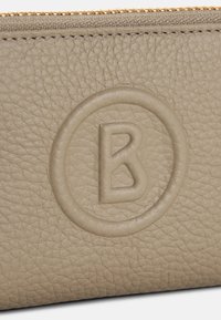Beige Leder-Wallet mit strukturiertem Finish, geprägtem kreisförmigem Logo mit "B" und goldener Reißverschlussöffnung.