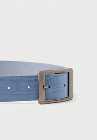 Lichtblauwe leren riem met een gestructureerde afwerking, voorzien van een zilverkleurige rechthoekige gesp en verstelbare gaatjes voor maatvoering.