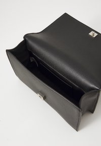 Borsa a mano in pelle nera con un design strutturato, dotata di chiusura a scatto in metallo argentato e un ampio interno con slot per carte.