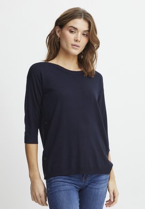 Pull léger bleu marine à manches trois-quarts, encolure ronde et accents de boutons sur le côté. Texture lisse et douce.
