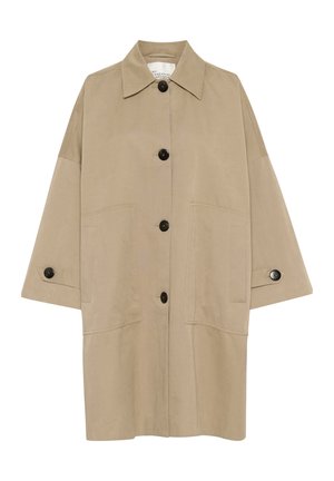 Beige oversized jacket with a sharp collar, front button closure, and large patch pockets. Features black buttons and a smooth texture.