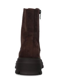 Braune Wildleder-Ankle Boots von hinten betrachtet, mit einer dicken schwarzen geriffelten Sohle und einem seitlichen Reißverschluss-Zip-Band, das sichtbar ist.