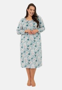 Długa koszula nocna z krótkim rękawem w miękkiej, jasnoniebieskiej tkaninie z kwiatowym wzorem w różowych i turkusowych akcentach. Okrągły dekolt i prosta sylwetka.