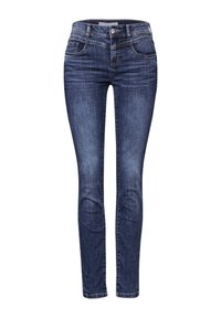 Jean skinny en denim bleu foncé. Les caractéristiques incluent une taille mi-haute, un design à cinq poches et des coutures discrètes le long des coutures.