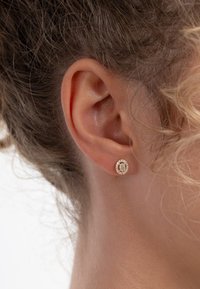 Roze gouden stud oorbellen hebben een ronde vorm met een centrale steen omgeven door kleinere kristallen, gezet in een gepolijste metalen basis.