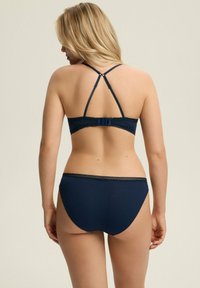 Granatowy zestaw biustonosza i majtek z koronkowymi akcentami. Biustonosz z regulowanymi krzyżującymi się ramiączkami i zapięciem na haftkę; gładki, dopasowany krój.