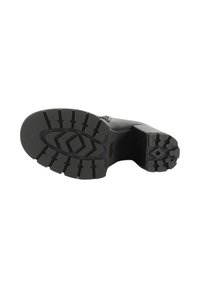 Sole in gomma nera con un motivo a battistrada testurizzato, caratterizzato da scanalature e forme a diamante in rilievo. La scarpa presenta un tacco quadrato e una tomaia liscia.