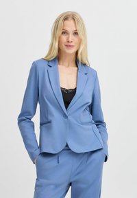 Blazer bleu clair avec une coupe ajustée, fermeture à un bouton, col à revers et deux poches avant, fabriqué dans un tissu lisse et texturé.