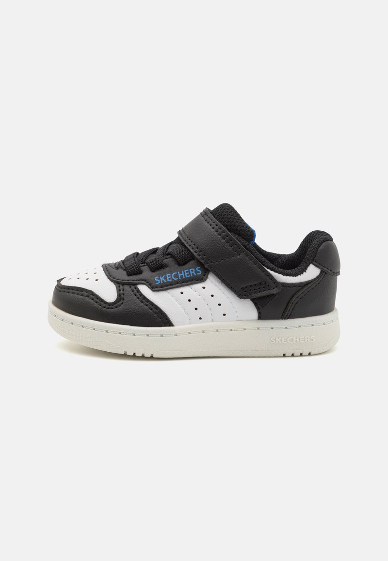 Crno-bijele tenisice s perfoiranim detaljima, čičak remenom, teksturiranom kožom i bijelom gumenom potplatom, s "SKECHERS" oznakom.