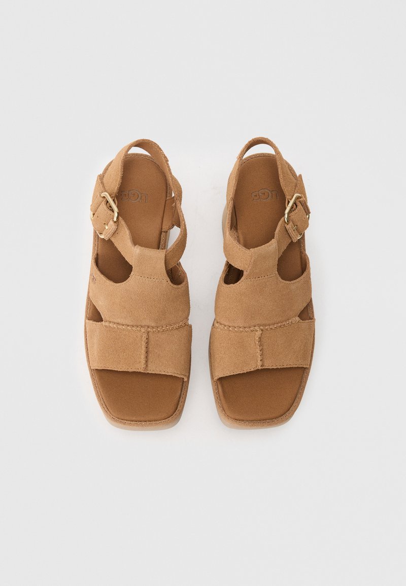 Sandalias de ante marrón con un diseño de punta abierta, hebilla ajustable y plantilla acolchada. Suela resistente con detalles de costura visibles.