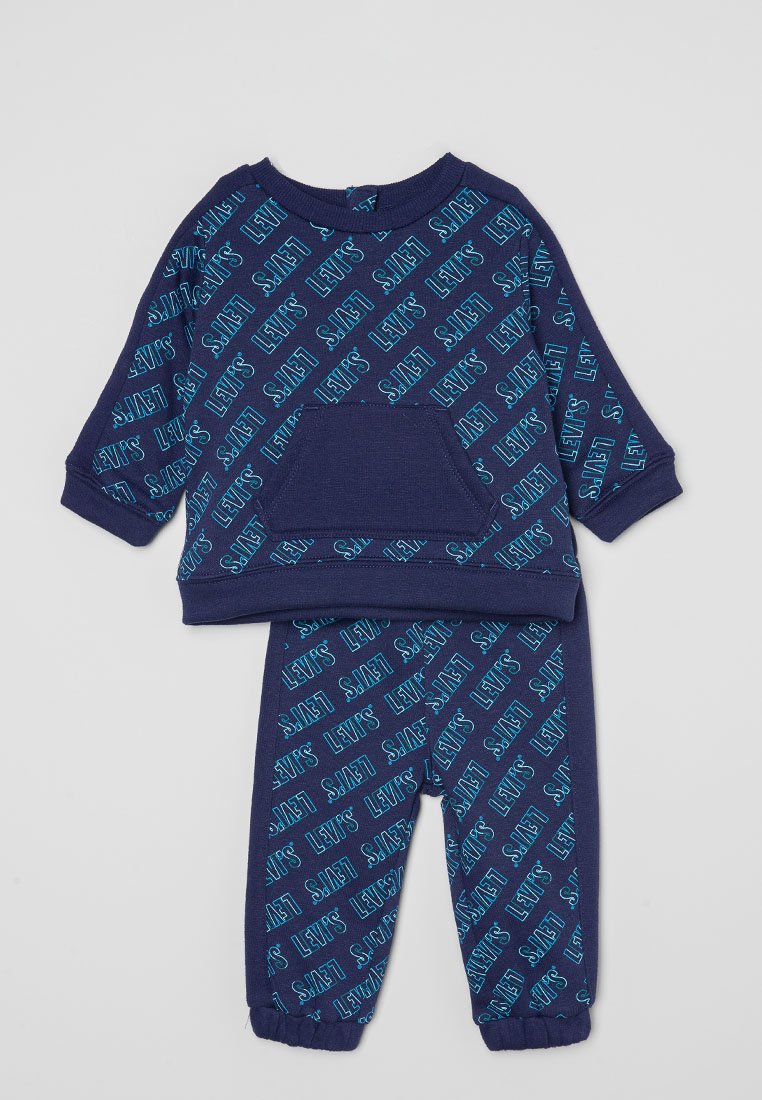 Conjunto de sudadera y pantalones en azul marino con un patrón repetido de logotipos en azul claro. La sudadera tiene un bolsillo frontal y puños anchos.