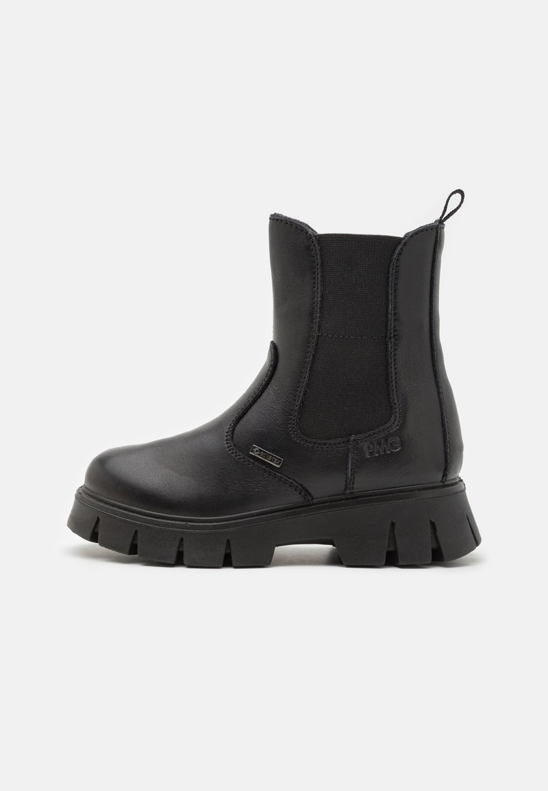 Botines negros con paneles laterales elásticos, que cuentan con una suela de goma gruesa y un acabado de cuero suave. Incluyen una lengüeta para facilitar su uso.