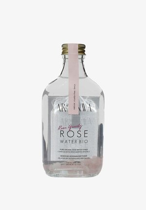 Bouteille en verre transparente contenant 200 ml de tonique à l'eau de rose, avec une étiquette rose, un bouchon doré et des cristaux de quartz rose visibles à la base.