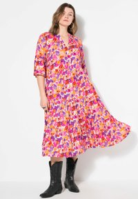 Kukkaistyyppinen maxi-mekko, jossa on V-pääntie, 3/4-hihat ja kerroksellinen muotoilu. Värit sisältävät vaaleanpunaisen, violetin ja oranssin vaalealla taustalla.