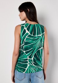 Ärmelloses Top aus grünem Stoff mit weißem Blättermuster, das ein Schlüssellochdetail im Rücken aufweist. Glatte Textur und leichtes Design.
