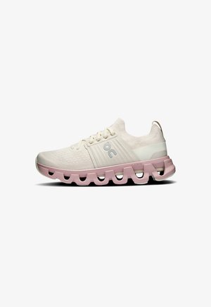 Lightweight running shoe in cream with pink sole. Features breathable mesh upper, rounded shape, and logo accent on the side.