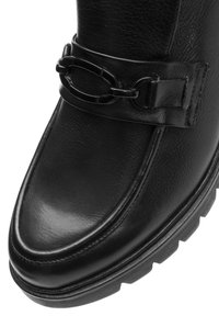 Schwarze Leder-Ankle-Boots mit glatter Oberfläche, runder Zehe und einem dekorativen Riemen mit Kettendetails. Dicke Gummisohle für besseren Halt.