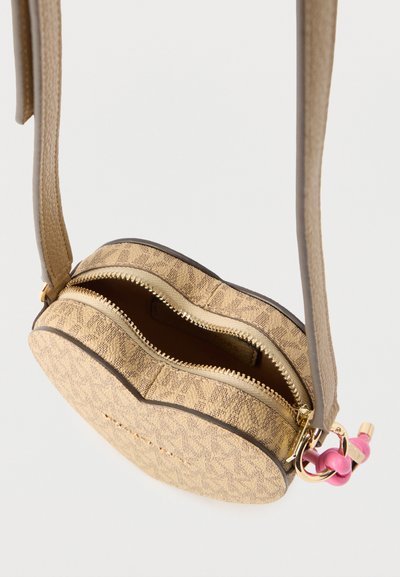 Μικρό μπεζ τσάντα χιαστί με μονογραμμικό σχέδιο, χρυστό φερμουάρ και ροζ κόμπος στη σύνδεση του ιμάντα.