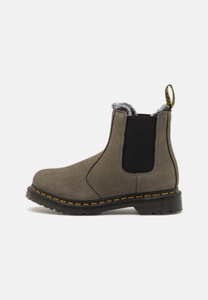 Gray leather ankle boot with elastic side panels, textured upper, faux fur lining, black rubber sole, and yellow stitching detail.