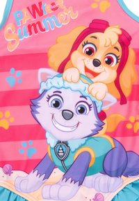 Pink swim tank featuring cartoon dogs. One is a smiling, blue-eyed husky with a teal outfit; the other is a playful golden retriever with a red headband.