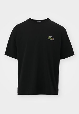 Black short-sleeve crewneck T-shirt with small green crocodile logo embroidered on left chest against plain background.
