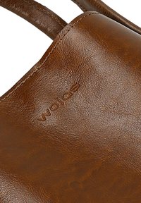 Brązowa skórzana torba tote o gładkiej teksturze, z subtelnym wytłoczonym logo. Torba ma mocne uchwyty i staranne detale przeszyć.